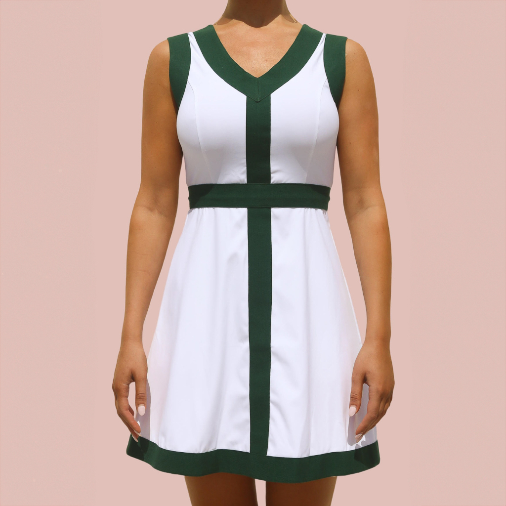 A young woman in a white and green pickleball dress