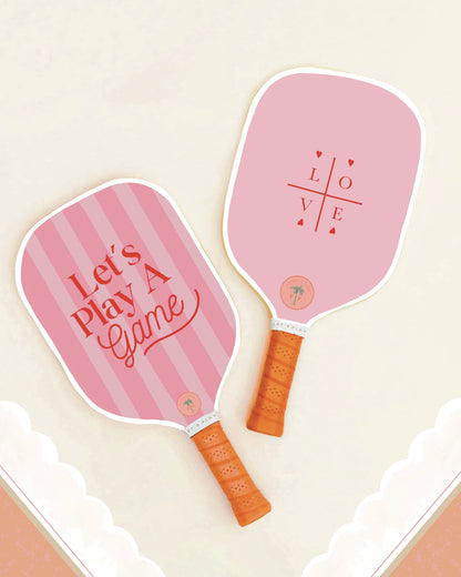 The front and back of a cute pickleball paddle with a pink design