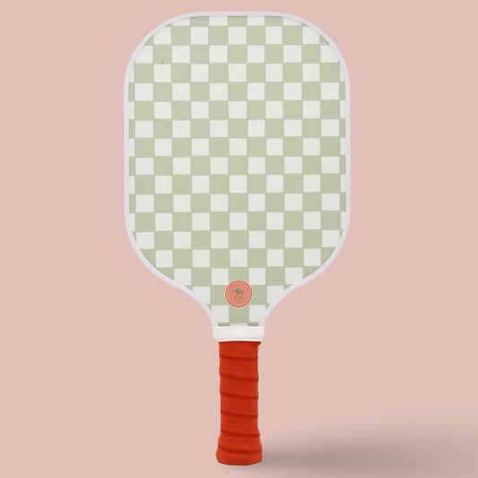 The back of a cute pickleball paddle with a yellow paddle and palm logo