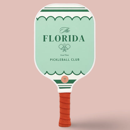 The front of a cute pickleball paddle with a green design