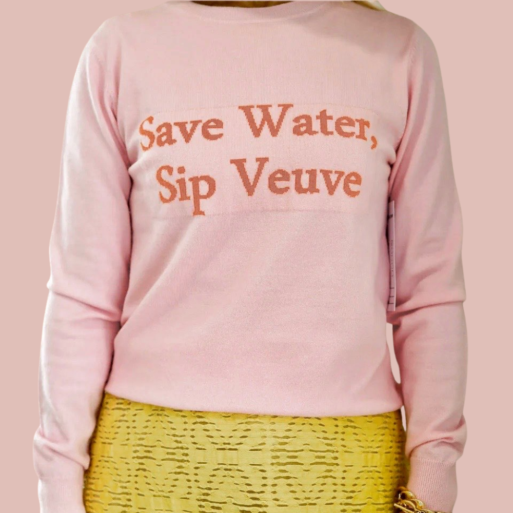 Pink sweatshirt with 'Save Water, Sip Veuve' text on a pink background