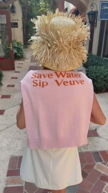 Woman wearing a pink sweater draped across her shoulders