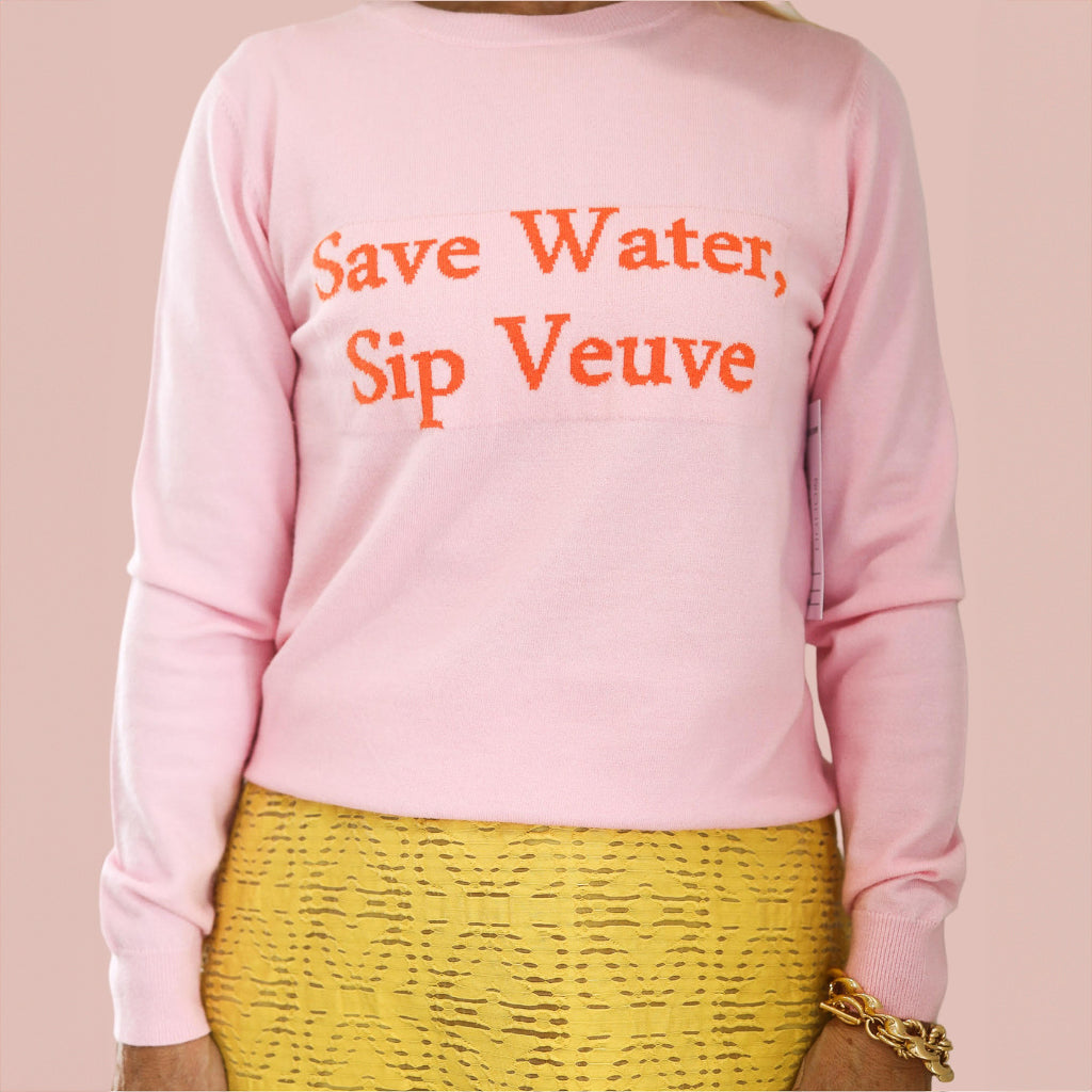 A pink sweater with the words "Save Water, Sip Veuve"